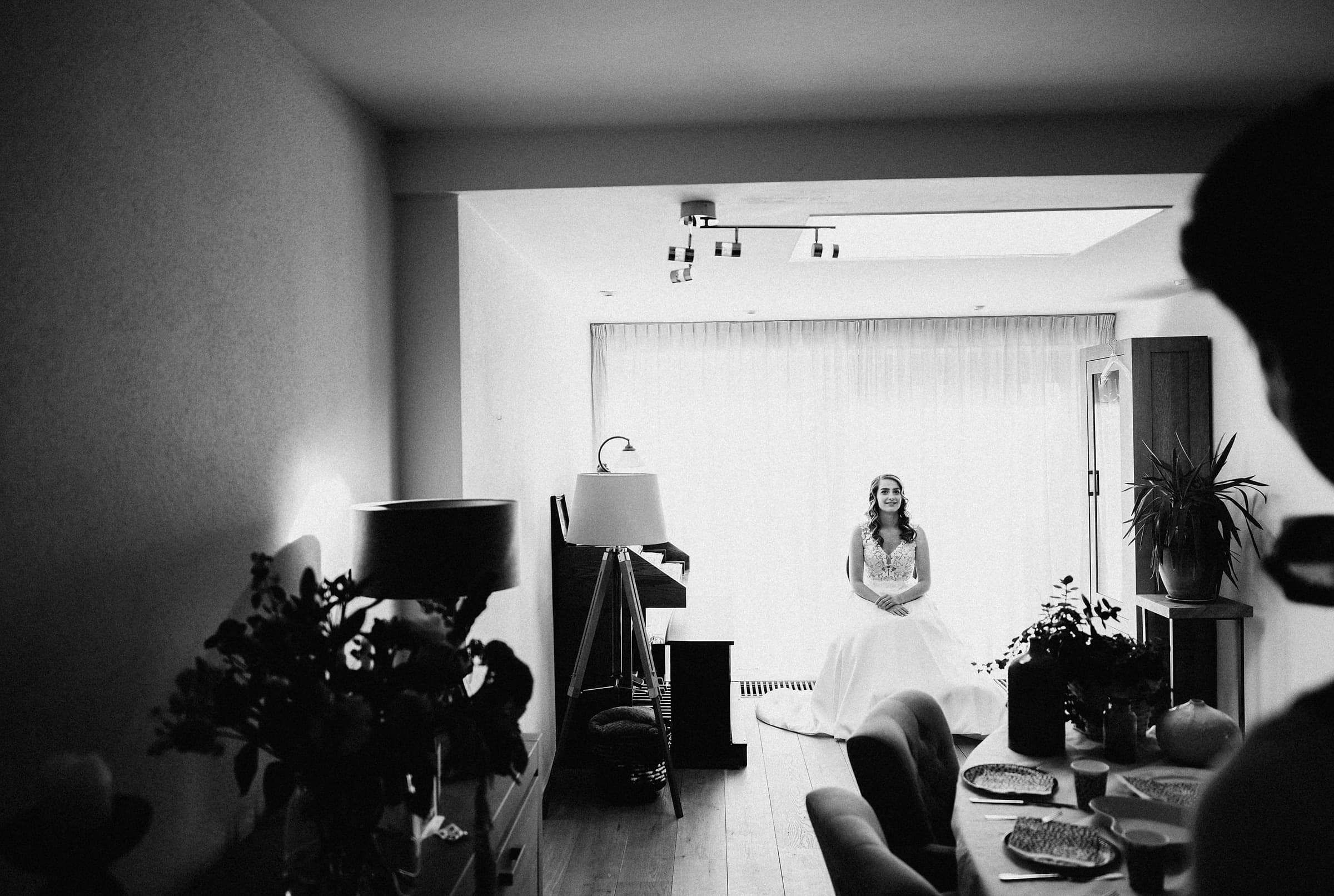 A bride sitting alone in soft window light before her wedding, a moment that exists only once