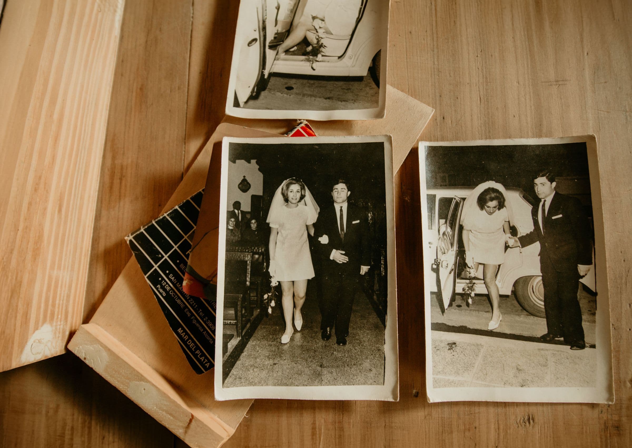 Black and white wedding prints laid out across a wooden table, ready to be chosen from
