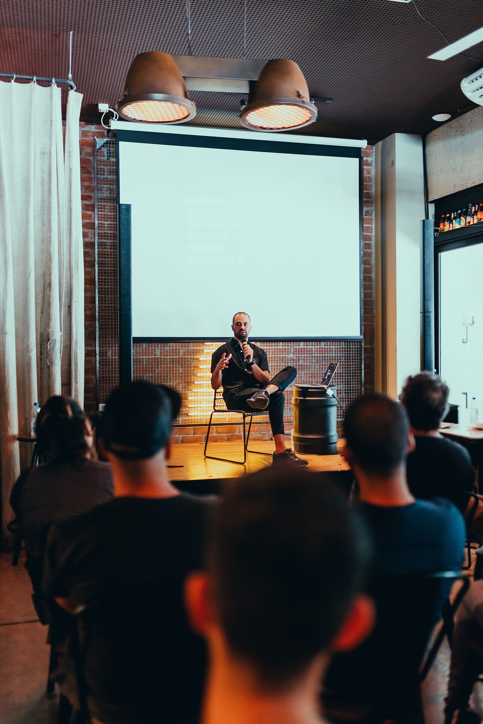 An audience seated in a venue watching a speaker on stage at a corporate event